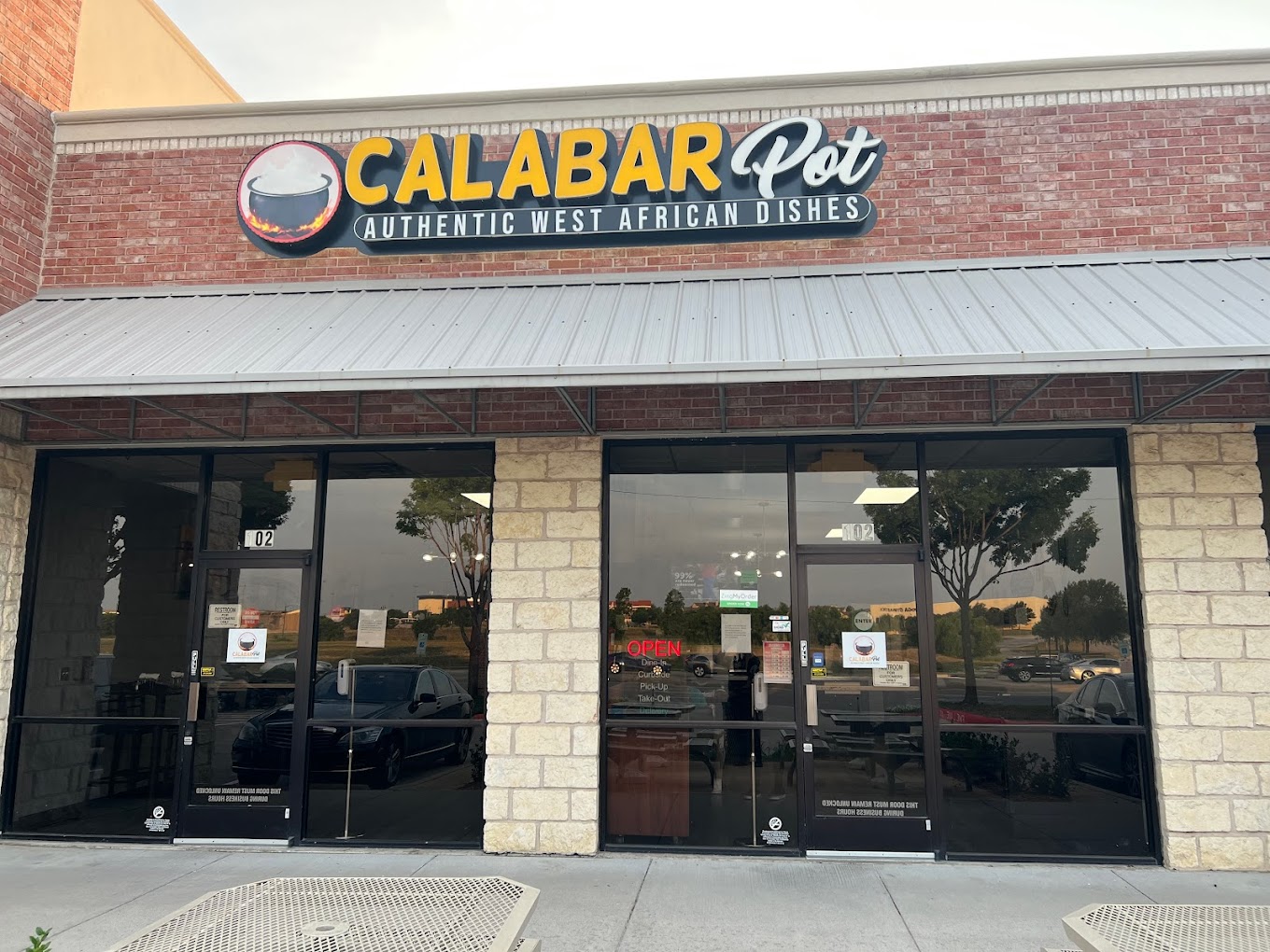 The real Calabar Pot storefront in Frisco, Texas, with its Authentic West African Dishes sign and OPEN sign lit in the window.