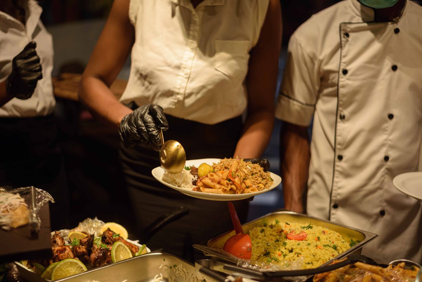 Full buffet spread of West African dishes set out for a catered event.