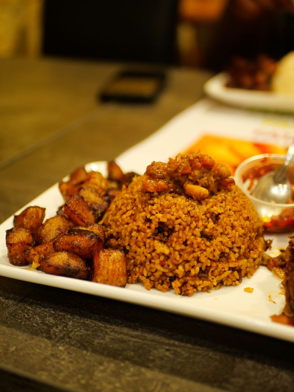 White rice with goat stew and fried plantain.
